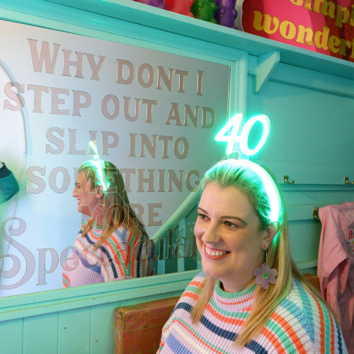 LED neon headband in white. Lights up with a supplied battery pack. Text or number can be customised